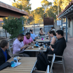 A group of people sitting at tables eating food.