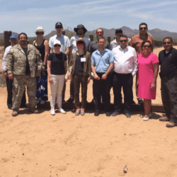 A group of people standing in the sand.