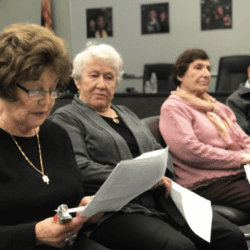 A group of people sitting in chairs looking at papers.