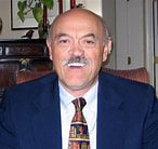 Smiling man in suit and tie indoors.