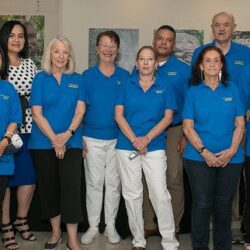 Group of people in matching blue shirts.