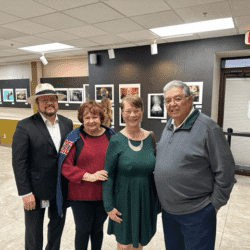 Four people posing in an art gallery.