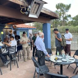 Outdoor gathering at a bar with people socializing.