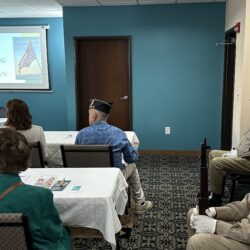 People attending a presentation in a small meeting room.